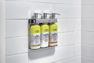 a wall mounted rack with four bottles of liquid at Holiday Inn Express & Suites - Woodstock, ON CANADA in Woodstock