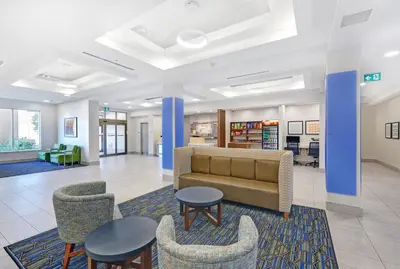 a lobby with a couch and chairs and tables at Holiday Inn Express & Suites - Woodstock, ON CANADA in Woodstock