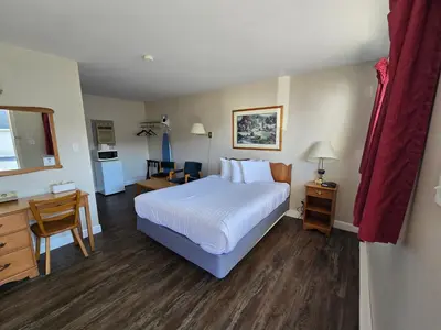 a hotel room with a bed and a desk and a room at Travelodge by Wyndham Port Elgin in Port Elgin