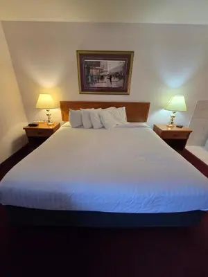 a bedroom with a large white bed with two lamps at Travelodge by Wyndham Port Elgin in Port Elgin