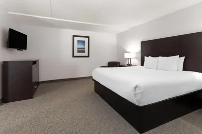 a hotel room with a bed and a flat screen tv at Travelodge by Wyndham Lindsay in Lindsay