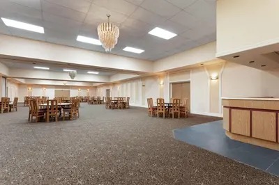 a large room with tables and chairs and a chandelier at Travelodge by Wyndham Lindsay in Lindsay