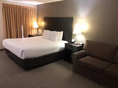 a hotel room with a bed and a couch at Travelodge by Wyndham Lindsay in Lindsay