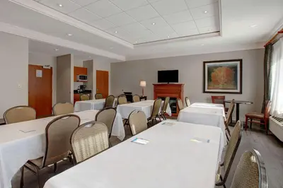 a conference room with tables and chairs and a tv at Days Inn & Suites by Wyndham Collingwood in Collingwood