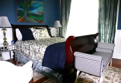 a bedroom with a bed and a chair at Historic Lyons House in Niagara on the Lake