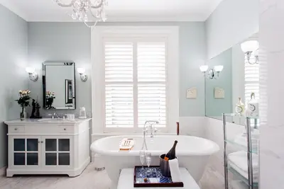 a white bathroom with a tub and a sink at Historic Lyons House in Niagara on the Lake