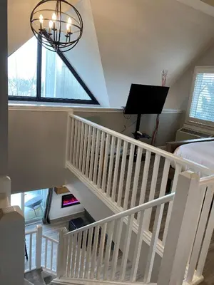 a room with a staircase with a bed and a window at Blue Mountain 2 Story Studio Loft in Blue Mountains