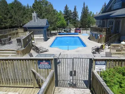 a large swimming pool with a deck and a house at Blue Mountain 2 Story Studio Loft in Blue Mountains