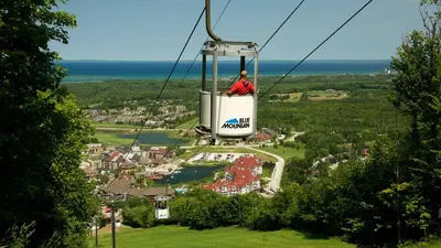 a person riding a gondola in the sky at Blue Mountain 2 Story Studio Loft in Blue Mountains