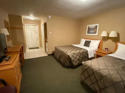 a hotel room with two beds and a television at Country Inn Listowel in Listowel
