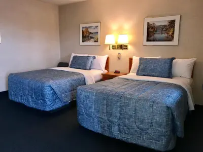 a hotel room with two beds with blue sheets at Country Inn Listowel in Listowel