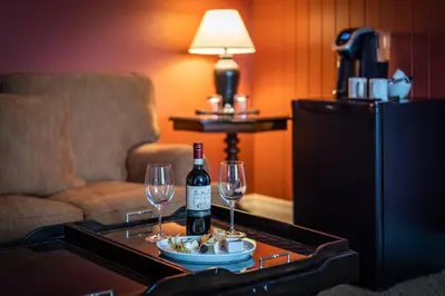 a room with a table with a bottle of wine and glasses at The Inn at Cobble Beach in Kemble