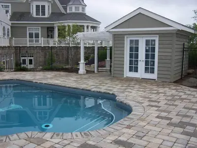 a swimming pool in front of a house at The Inn at Cobble Beach in Kemble