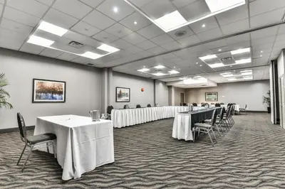a large room with tables and chairs with white table cloths at Best Western Plus Cambridge Hotel in Cambridge