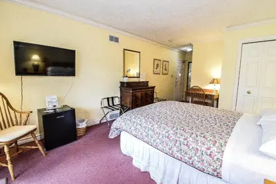 a hotel room with a bed and a desk and chair at Blairpen House Country Inn in Niagara on the Lake