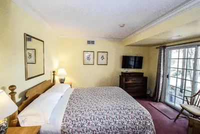a bedroom with a bed and a tv and a window at Blairpen House Country Inn in Niagara on the Lake