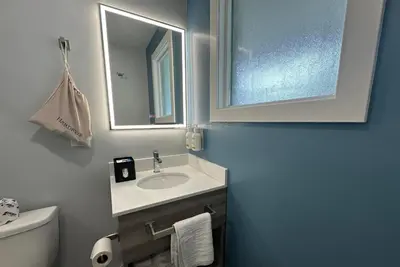 a bathroom with a sink and a mirror and a toilet at Travelodge by Wyndham Bracebridge in Bracebridge