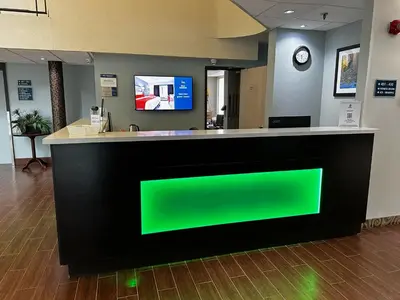 a green sign on a counter in a lobby at Best Western Little River Inn in Simcoe