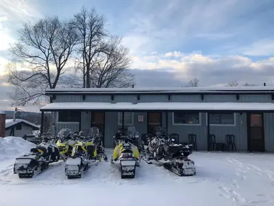 a group of snowmobiles parked in front of a building at Lakeview Motel in Haliburton