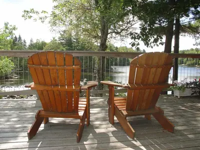 two wooden chairs sitting next to each other on a deck at Sunny Rock Bed & Breakfast in Minden