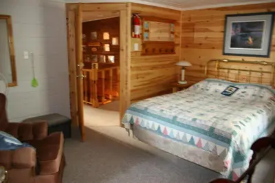 a bedroom with a bed in a wooden room at Sunny Rock Bed & Breakfast in Minden