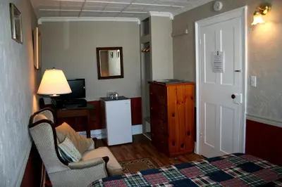 a room with a bedroom with a bed and a tv at Hadovka Lakeside Inn in Wellington
