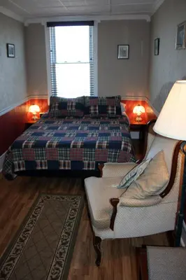 a bedroom with a bed and a couch and a chair at Hadovka Lakeside Inn in Wellington