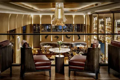 a restaurant with a table and chairs and a chandelier at The St. Regis Toronto in Toronto