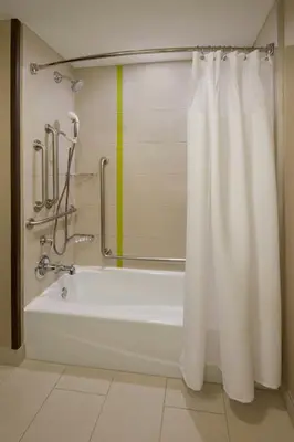 a bathroom with a bath tub with a yellow stripe at SpringHill Suites by Marriott Toronto Vaughan in Vaughan