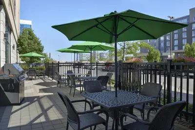 a patio with tables and chairs with green umbrellas at SpringHill Suites by Marriott Toronto Vaughan in Vaughan