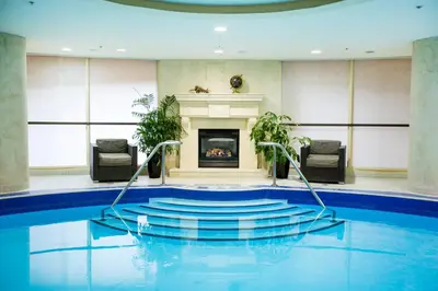 a swimming pool with a fireplace in a room at Windsor Arms Hotel in Toronto