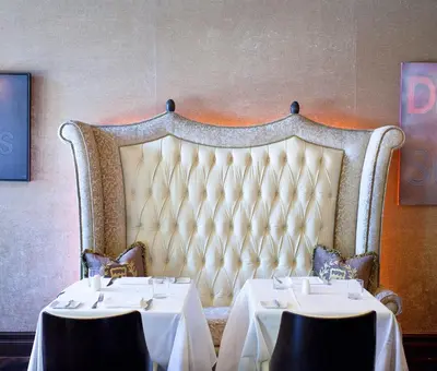 a dining room with two tables with white tablecloths at Windsor Arms Hotel in Toronto