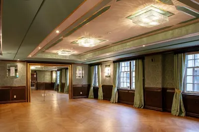 a large room with a wooden floor and windows at Windsor Arms Hotel in Toronto