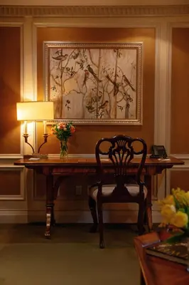 a room with a desk with a chair and a lamp at Windsor Arms Hotel in Toronto