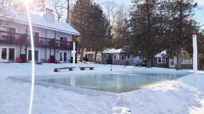 a swimming pool covered in snow in front of a building at Bonnie View Inn in Haliburton