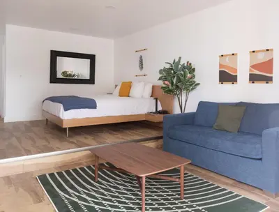 a living room with a bed and a blue couch at Bonnie View Inn in Haliburton