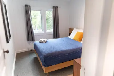 a bedroom with a bed with two towels on it at Bonnie View Inn in Haliburton