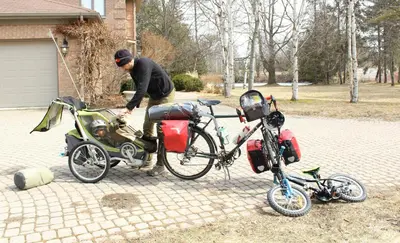 a man standing next to a bike with a cart at Tailwinds B&B in Erin