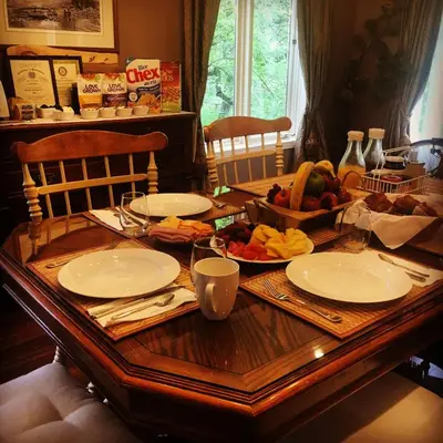 a wooden table with plates and a bowl of fruit at Tailwinds B&B in Erin
