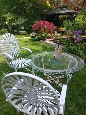a glass table and two chairs in a yard at TwiningRetreat in Niagara on the Lake