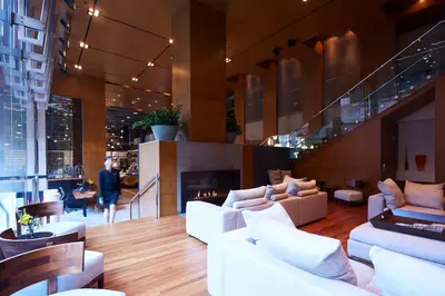 a lobby with white couches and a fire place at Le Germain Hotel Toronto in Toronto