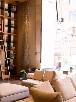 a living room with couches and a large window at Le Germain Hotel Toronto in Toronto