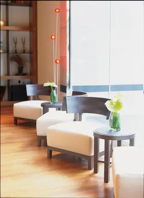 a lobby with chairs and tables and a window at Le Germain Hotel Toronto in Toronto
