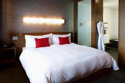 a bedroom with a large white bed with red pillows at Le Germain Hotel Toronto in Toronto