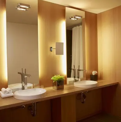 a bathroom with two sinks and a large mirror at Le Germain Hotel Maple Leaf Square in Toronto