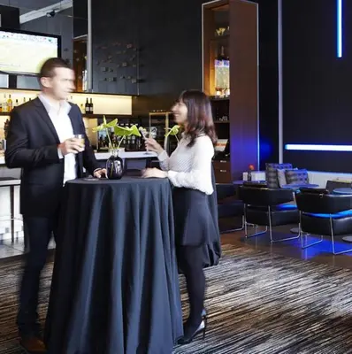a man and a woman standing around a table at Le Germain Hotel Maple Leaf Square in Toronto