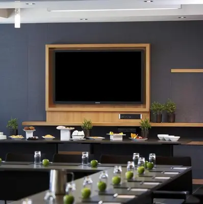 a room with tables and a flat screen television at Le Germain Hotel Maple Leaf Square in Toronto