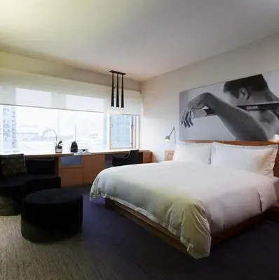 a bedroom with a bed and a desk and a chair at Le Germain Hotel Maple Leaf Square in Toronto