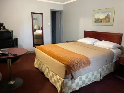 a hotel room with a large bed and a table at Liberty Inn in Bowmanville