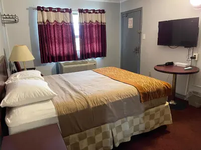 a hotel room with a bed and a television at Liberty Inn in Bowmanville